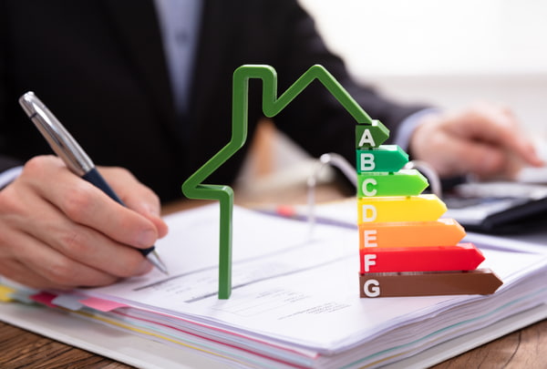 House model showing energy efficiency rate in front of businessperson's